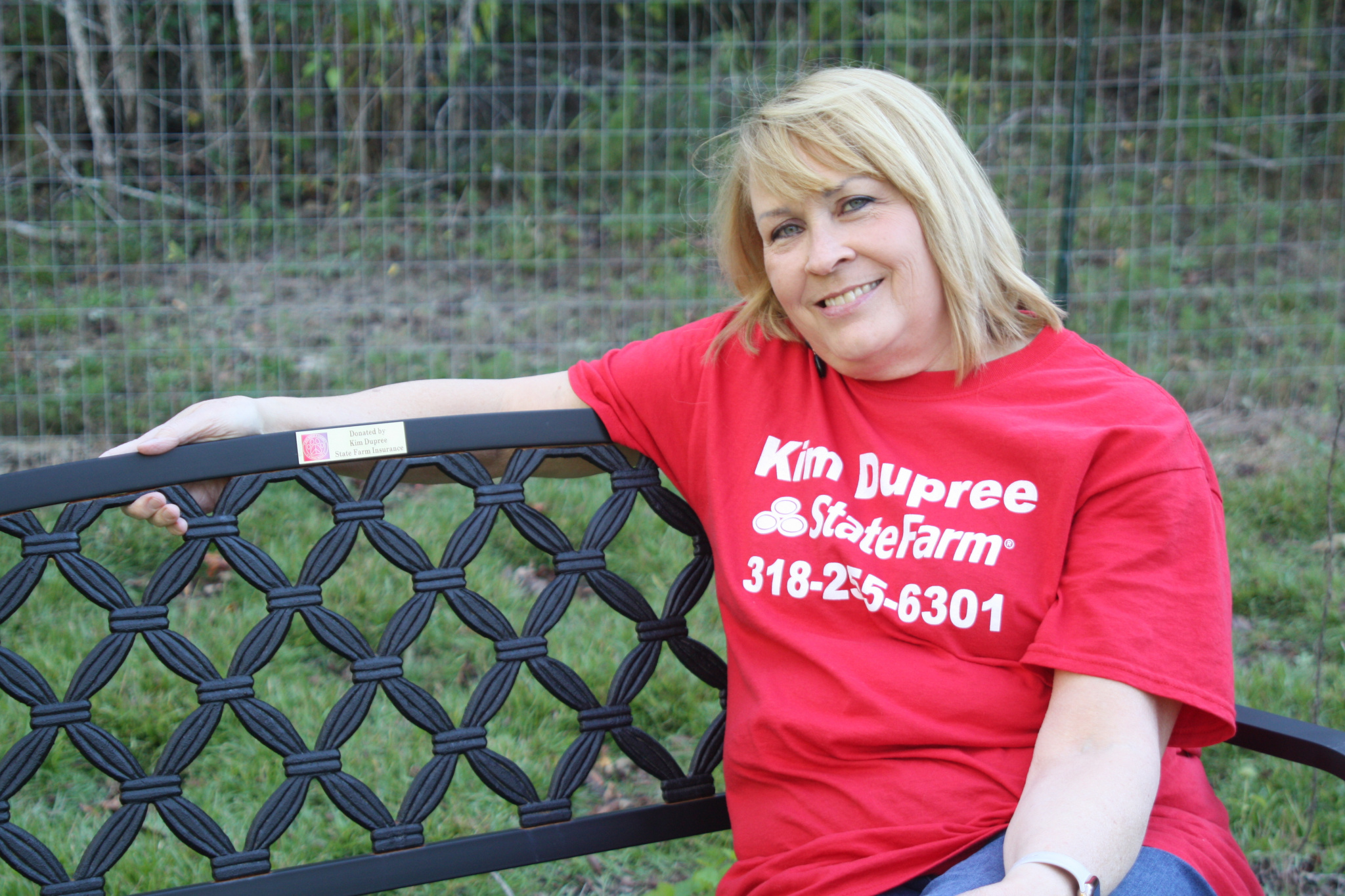Kim Dupree sitting at the bench she sponsored at the dog park
