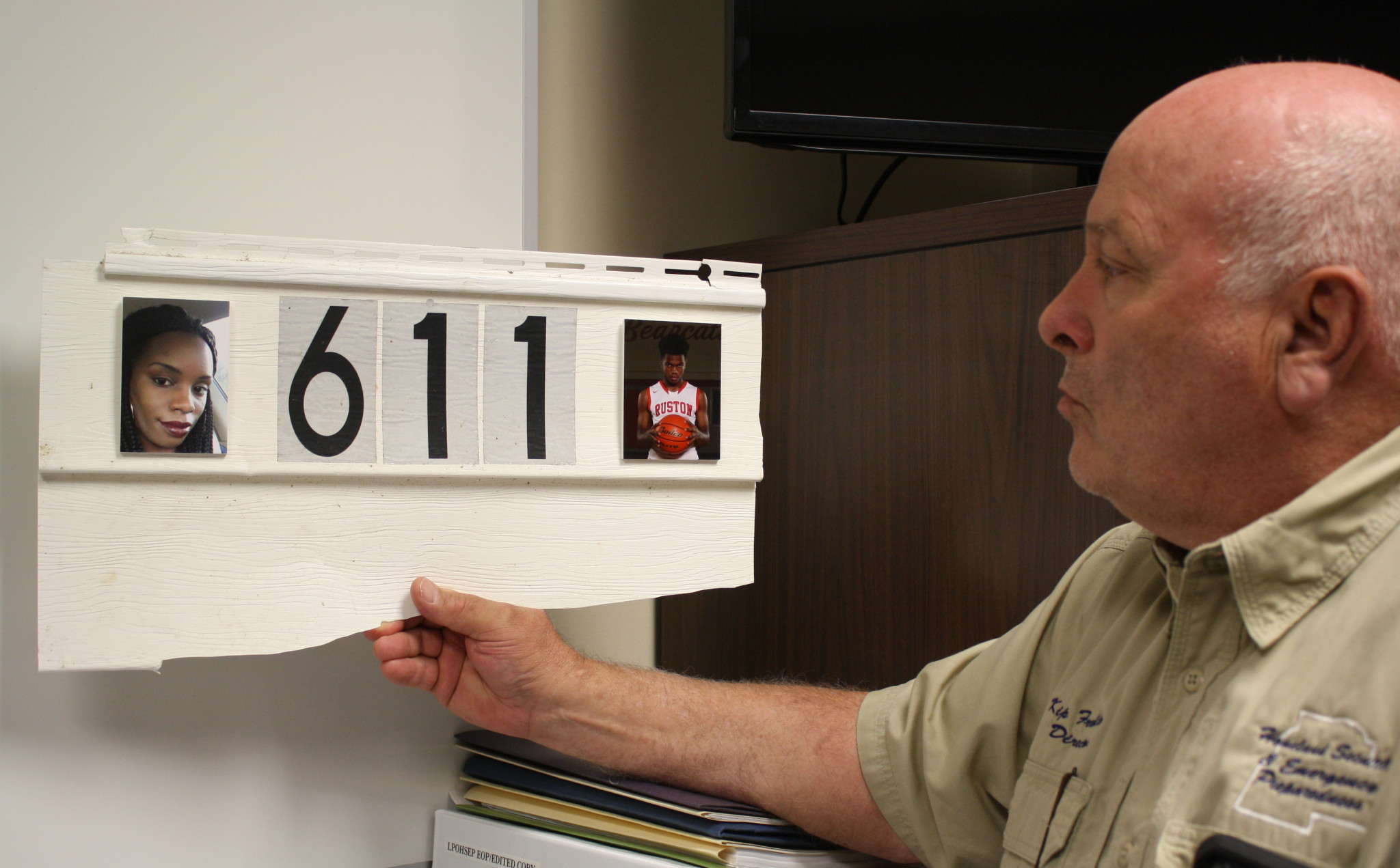 <span style="font-size:12pt"><span style="font-family:&quot;Times New Roman&quot;">Lincoln Parish Director of Homeland Security and Emergency Preparedness Kip Franklin holds a piece of siding from the Evans Street house where Kendra and Remington Butler lost their lives during the tornado. It hangs in Franklin’s office with pictures of the Butlers affixed to it.</span></span>